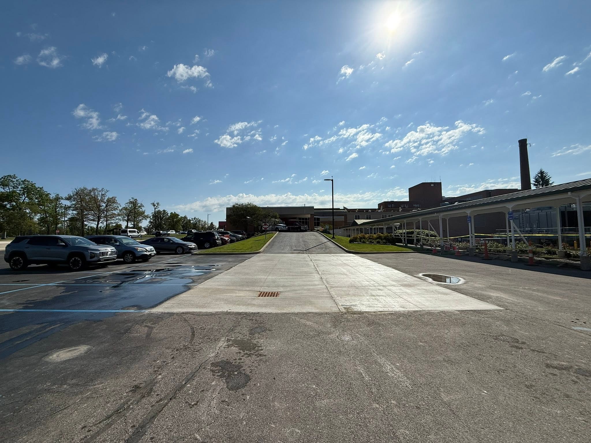 The same medical center entrance with a freshly poured concrete approach ramp