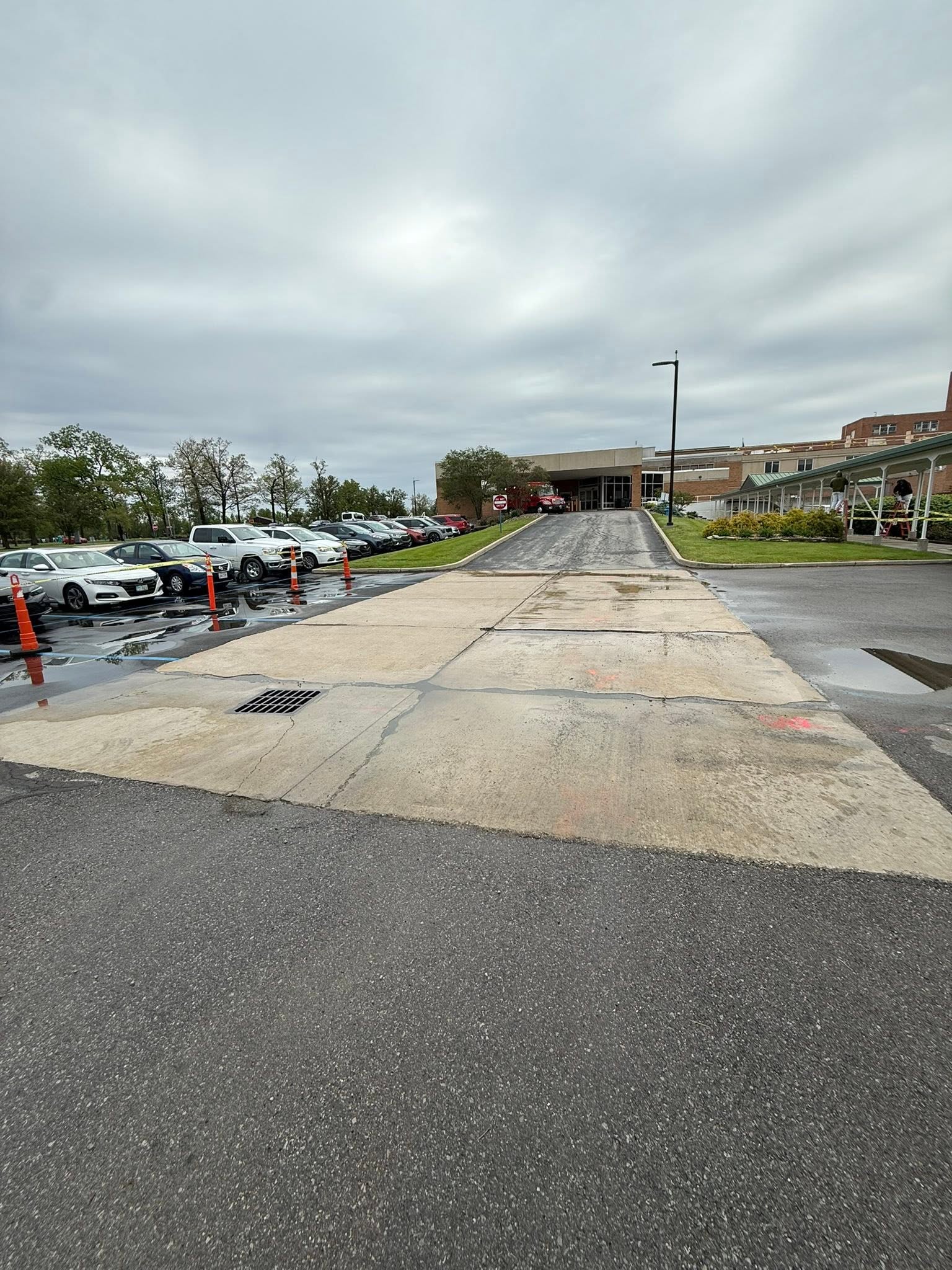 Cracked and stained concrete approach at a medical center entrance before replacement